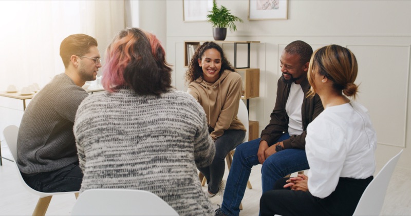 A recovery group meeting together in a bright room