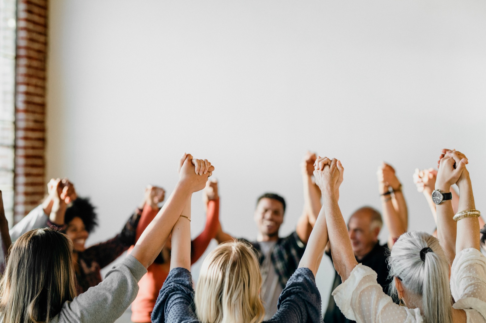 Men and supporters raising joined hands together in celebration of recovery