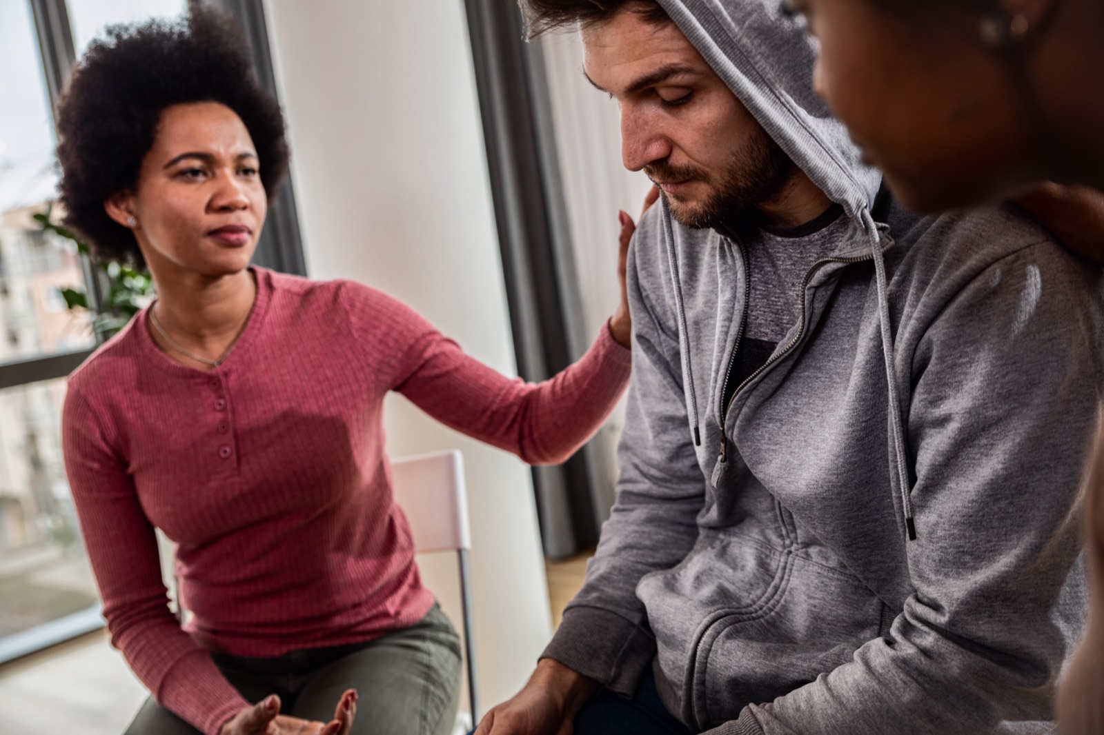 Peers offering support to a man during a recovery group session