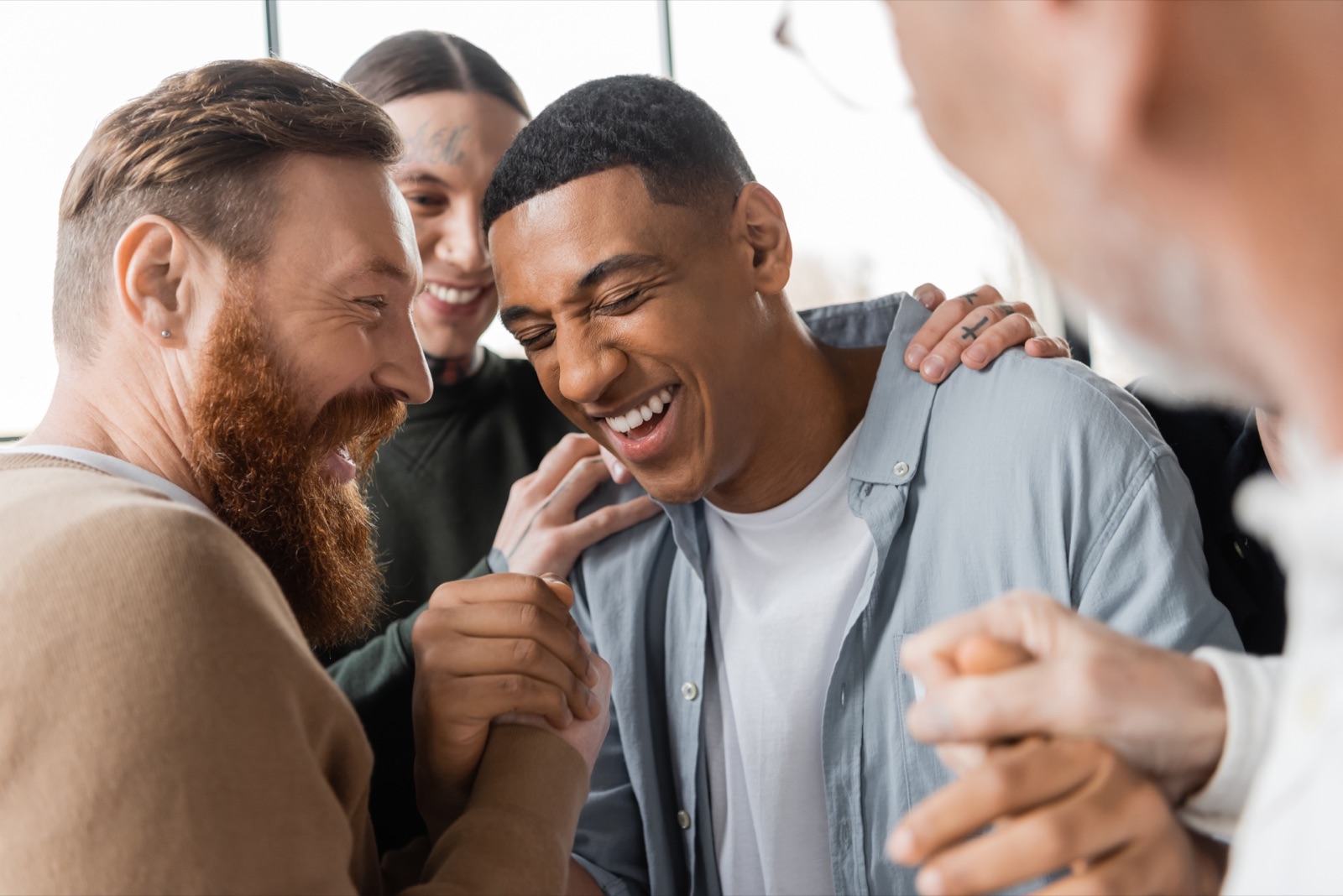 Two men laughing together during a recovery group at Benilde Hall